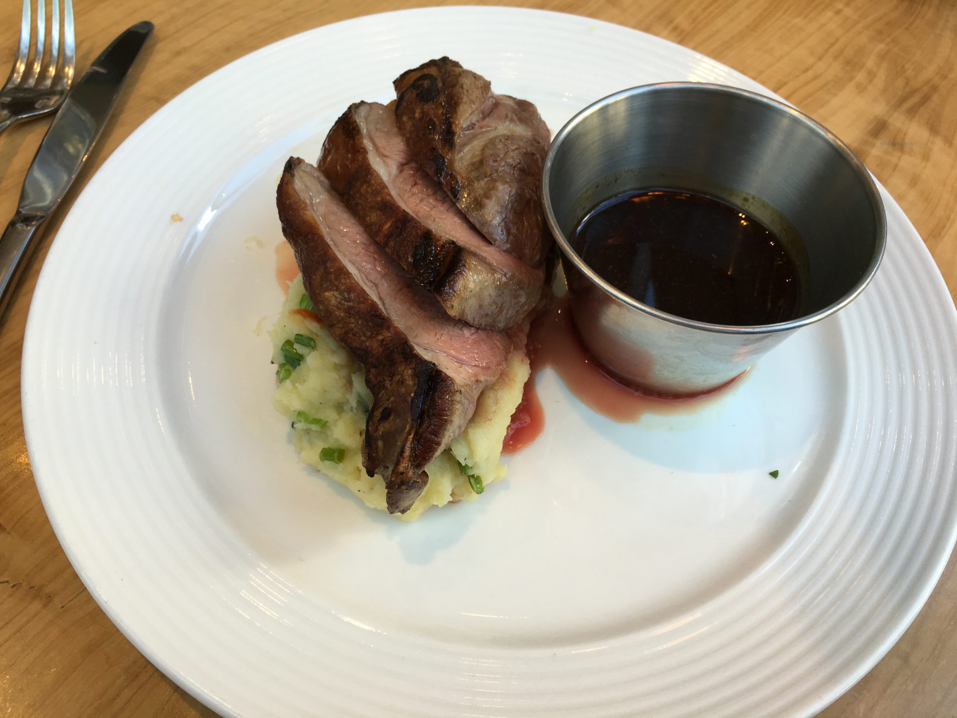 Roasted lamb with spring onion mash potato, whole roasted garlic cloves & a red wine jus